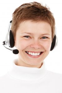 short haired lady ,enormous smile with headset ready to chat