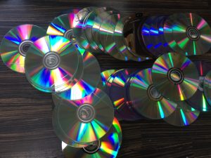 silver shiny cd discs spread on table for recycycling
