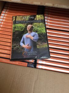 box of packed dvds with one on top showing man doing breathing techniques