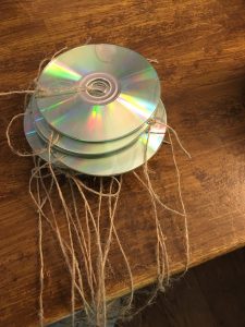 cds with burn side showing ties through centre hole with string