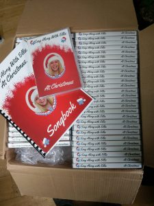 Box of dvds with Christmas theme cover and christmas songbook