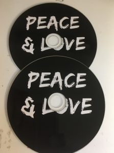 black disc with white text Peace & Love